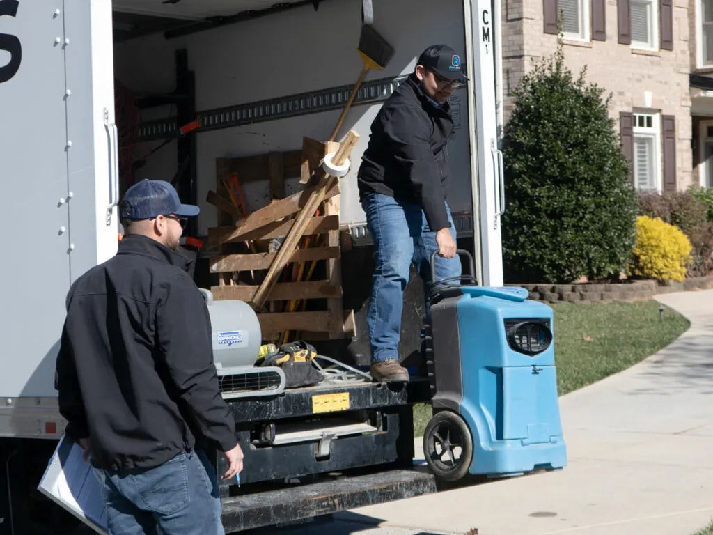 Two employees unloading restoration equipment